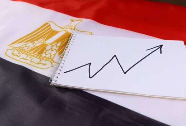 A notepad features a rising trend line, resting on the vibrant Egyptian flag, symbolizing financial growth and economic development within the country.