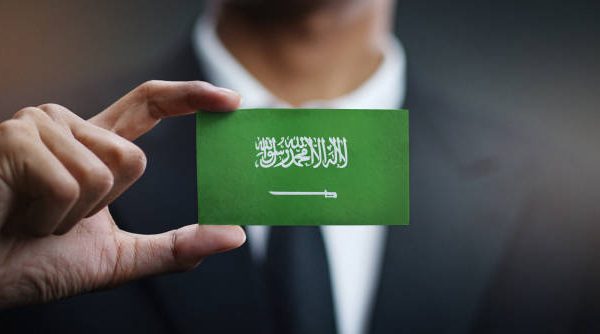 Businessman Holding Card of Saudi Arabia Flag